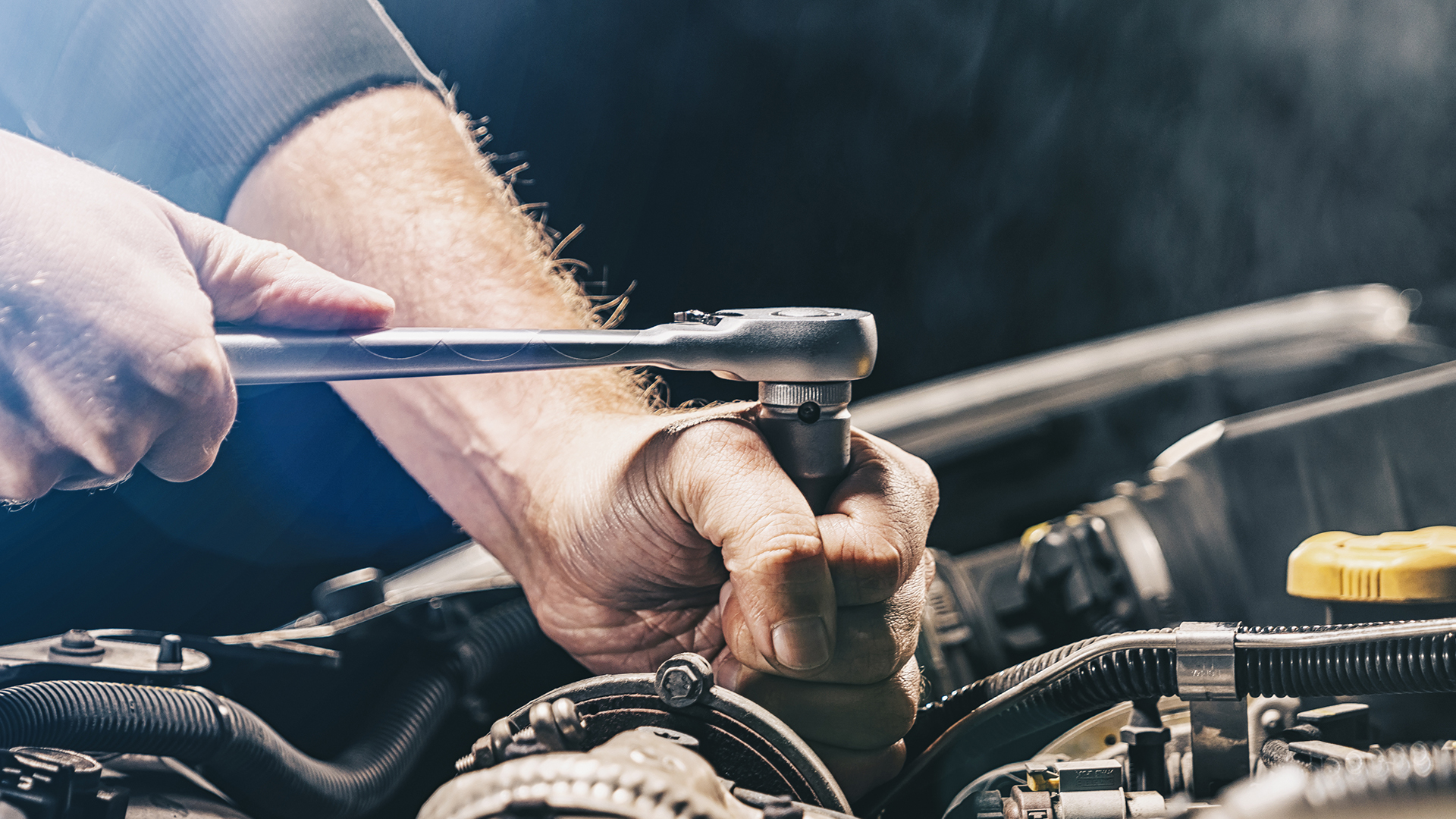 Fleet maintenance mechanic with a socket wrench working on a fleet vehicle that is due for maintenance from direction from SM2 Fleet Maintenance Management Systems